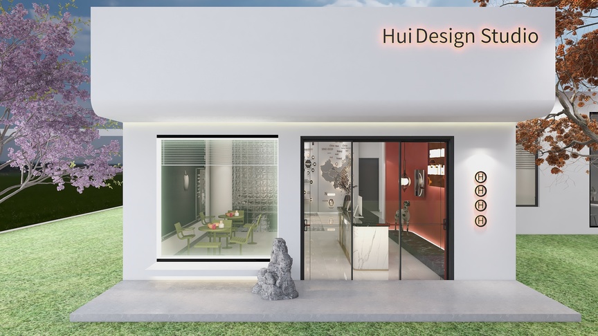 这个建筑是一个设计工作室，白色简约的外观，门口右侧有一个石头艺术品，门口左右两侧分别有一个红棕色的门和一个玻璃门，进入室内，左手边是一张黑色玻璃桌，上面摆放着一些设计作品，桌子周围是绿色的草坪和假山，桌子上方的吊顶是乳白色的，上面中央有一个白色的吊灯，假山右侧是一面灰色的砖墙，墙面是浅灰色的，墙面上挂着一些艺术品，艺术区的右侧是开放的厨房，厨房里有一张红色的餐台和绿色的餐椅，餐椅上摆放着黄色的餐盘，厨房的墙面是深灰色的，地面是浅灰色的，厨房的门口是玻璃推拉门，推拉门的左右两侧分别是白色的窗户和日字型的窗户，日字型窗户的左右两侧分别是圆形的窗户和长方形的窗户，窗户都配有白色的框架，室外的樱花树和樱花和草坪、假山与建筑融为一体，形成了一幅美丽的风景画。