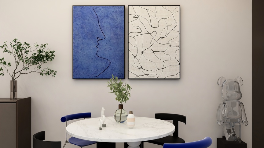 图中是一个餐厅，餐厅的墙面是白色的，墙上挂着两幅画，画的下方有一个圆桌，上面有白色的桌子和黑色的桌腿，还有四个不同颜色的椅子围绕着桌子。
