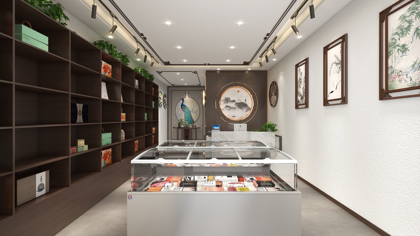 展示的是一个店铺的内部装修，店铺整体以白色和棕色为主色调，显得整洁明亮。店铺的左侧墙壁上摆放着一个高约2米的玻璃冰柜，冰柜内部有多种商品展示，其中底部有几排颜色不同的寿司展示。冰柜上方的墙壁上挂着一个装饰有蓝色花纹的鸟的挂饰，以及两个圆形的装饰画，画面是蓝色的山峰画面。冰柜前方的墙壁上镶嵌着一块白色大理石纹的装饰板。店铺的中间摆放着一个装有绿色植物的玻璃花盆，右侧的墙壁上挂着三幅装饰画，画面上是绿色的植物和蓝色的鸟。画的下方有一个白色的大理石纹的底座，上面摆放着一个白色的陶瓷花盆。